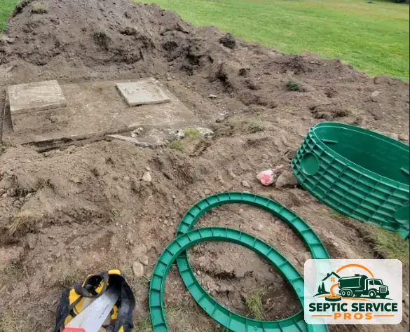 Old concrete septic lids uncovered next to new plastic riser rings, ready for a riser install
